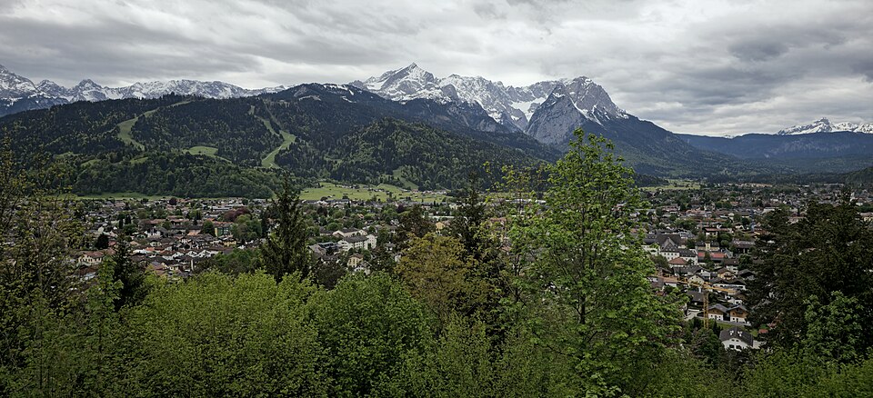Panorama of Garmisch-Partenkirchen town in the valley below the snow-covered Wetterstein mountains.