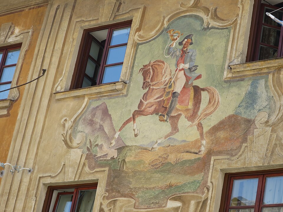 Painted fresco of a rider on horseback between windows on a historic Partenkirchen facade.